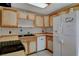 Traditional kitchen with light wood cabinets, tile flooring, and a white refrigerator at 132 Continental Ave, Henderson, NV 89015
