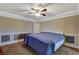 Carpeted main bedroom with a decorative ceiling fan and a large bed with a blue comforter at 132 Continental Ave, Henderson, NV 89015