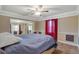 Carpeted main bedroom with a decorative ceiling fan and a large bed with a blue comforter at 132 Continental Ave, Henderson, NV 89015