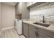 Laundry room with granite countertop and gray cabinets at 1559 Via Della Scala, Henderson, NV 89052