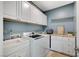 Laundry room with white cabinets, a utility sink, and washer/dryer at 1836 La Calera Ave, North Las Vegas, NV 89084