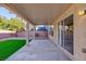 Covered patio extends from a well-manicured backyard featuring low maintenance gravel and synthetic grass at 312 Bella Calabria Ave, Las Vegas, NV 89183
