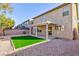 View of the backyard featuring a covered patio, low maintenance gravel, and synthetic grass at 312 Bella Calabria Ave, Las Vegas, NV 89183