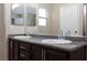 Bathroom featuring a granite double vanity with modern faucets and tiled wall mirrors at 312 Bella Calabria Ave, Las Vegas, NV 89183