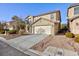 Two-story house with beige exterior, attached garage, and landscaping at 312 Bella Calabria Ave, Las Vegas, NV 89183