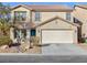 Tan two-story house with teal door, attached garage, and landscaping at 312 Bella Calabria Ave, Las Vegas, NV 89183