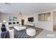 Staged living room with white couch, decorative pillows, leather ottoman, wall-mounted TV and modern décor at 312 Bella Calabria Ave, Las Vegas, NV 89183