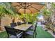 A cozy outdoor dining area with table, chairs, and patio umbrella in a lush backyard setting at 334 Sea Rim Ave, Las Vegas, NV 89148