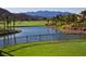 Golf course backyard with lake view, lush grass, wrought iron fence and mountain views in the distance at 334 Sea Rim Ave, Las Vegas, NV 89148
