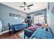 Blue bedroom featuring hardwood floors, ceiling fan, large window, workspace, and two twin beds at 334 Sea Rim Ave, Las Vegas, NV 89148
