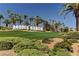Landscaped entrance to Rhodes Ranch features a hillside and iconic community name with numerous palm trees at 334 Sea Rim Ave, Las Vegas, NV 89148