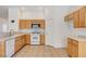 Kitchen with oak cabinets, white appliances, and tile floor at 641 Brad St, Henderson, NV 89015