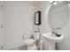 Clean and bright bathroom with pedestal sink and large mirror at 6521 Taffrail Ave, Las Vegas, NV 89118