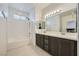 Bright bathroom with double sinks, large mirrors, and combined tub and shower at 6521 Taffrail Ave, Las Vegas, NV 89118