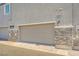 Attached garage with a modern door and stone accents at 6521 Taffrail Ave, Las Vegas, NV 89118