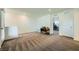 Open living room area with carpet floors, and access to a home office and bedroom at 6521 Taffrail Ave, Las Vegas, NV 89118