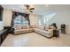 Comfortable living room with a large sectional sofa, decorative curtains, and a ceiling fan at 6521 Taffrail Ave, Las Vegas, NV 89118