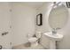 Bright powder room featuring a pedestal sink, toilet, and a minimalist mirror at 6521 Taffrail Ave, Las Vegas, NV 89118