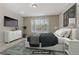 Cozy bedroom with a large window, TV, modern dresser and soft, inviting bedding at 7659 Dewy Falls Ave, Las Vegas, NV 89179