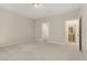 A neutral toned bedroom has carpeted floors and two open doorways, one to the en suite at 7659 Dewy Falls Ave, Las Vegas, NV 89179