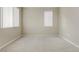 Simple bedroom with neutral carpet, two windows and horizontal blinds at 7659 Dewy Falls Ave, Las Vegas, NV 89179