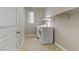 Convenient laundry room with washer, dryer, storage shelf and tile flooring at 7659 Dewy Falls Ave, Las Vegas, NV 89179