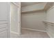 A walk-in closet features carpet flooring and multiple horizontal racks for storage at 7659 Dewy Falls Ave, Las Vegas, NV 89179