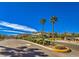 Gated community entrance with lush landscaping and signage at 9094 Palmas Altas St, Las Vegas, NV 89178