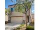 Two-story house with tan siding, stone accents, and a two-car garage at 9417 Sand Tiger Ave, Las Vegas, NV 89148