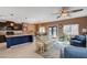 Open concept kitchen and living area with dark cabinets, granite counters, and blue island at 9417 Sand Tiger Ave, Las Vegas, NV 89148