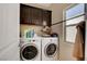 Laundry room featuring a side-by-side washer and dryer and upper storage cabinets at 9417 Sand Tiger Ave, Las Vegas, NV 89148