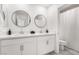 Double vanity bathroom with white cabinets and round mirrors at 10009 Cabernet Hills St, Las Vegas, NV 89141