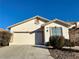 Single-story house with beige exterior, two-car garage, and well-maintained landscaping at 10030 Mystic Moss St, Las Vegas, NV 89183