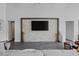 Modern living room showcasing a large TV, stone feature wall, and hardwood floors at 10271 Meridian Hill Ave, Las Vegas, NV 89135