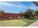 Spacious backyard featuring an artificial putting green, brick wall, and manicured landscaping at 10273 Aragon Crown Rd, Las Vegas, NV 89135