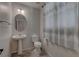 Bathroom with pedestal sink, toilet, decorative shower curtain and tile flooring at 10273 Aragon Crown Rd, Las Vegas, NV 89135