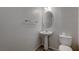 Clean bathroom with a pedestal sink, toilet, mirror, and tile flooring at 10273 Aragon Crown Rd, Las Vegas, NV 89135