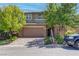 Charming two-story house showcasing a brick-paved driveway, a two-car garage, and mature trees at 10273 Aragon Crown Rd, Las Vegas, NV 89135