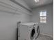 Bright laundry room featuring a front loading washer and dryer, shelving, and window at 10273 Aragon Crown Rd, Las Vegas, NV 89135