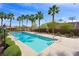 Community swimming pool surrounded by palm trees and well-maintained landscaping at 10280 Gilmore Canyon Ct # 203, Las Vegas, NV 89129