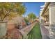 Landscaped backyard with stone wall, artificial turf, and plants at 10611 Auburn Springs Ave, Las Vegas, NV 89166