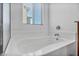 Relaxing bathtub with tile surround and window at 10611 Auburn Springs Ave, Las Vegas, NV 89166