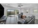 Spacious living room with dark hardwood floors,sliding glass doors, and a ceiling fan at 10611 Auburn Springs Ave, Las Vegas, NV 89166