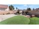 Backyard patio with fire pit, artificial turf, and a brick wall at 1064 Wide Brim Ct, Henderson, NV 89011