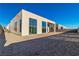 A view of the backyard shows a home with large picture windows in a desert environment at 10739 Agate Cliffs Ave, Las Vegas, NV 89135