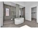 Bathroom featuring a modern soaking tub, glass shower, and sleek gray tile at 10739 Agate Cliffs Ave, Las Vegas, NV 89135