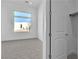 Bright bedroom featuring neutral carpet, a large window, and a walk-in closet with all-white walls and doors at 10739 Agate Cliffs Ave, Las Vegas, NV 89135