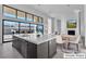 Modern kitchen with view to dining room, featuring stainless steel appliances and large island with sink at 10739 Agate Cliffs Ave, Las Vegas, NV 89135