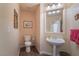 Clean and modern half bathroom with pedestal sink and wood-look tile floor at 1105 Thornfield Ln, Las Vegas, NV 89123