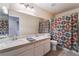 Clean bathroom with double sinks and patterned shower curtain at 1105 Thornfield Ln, Las Vegas, NV 89123